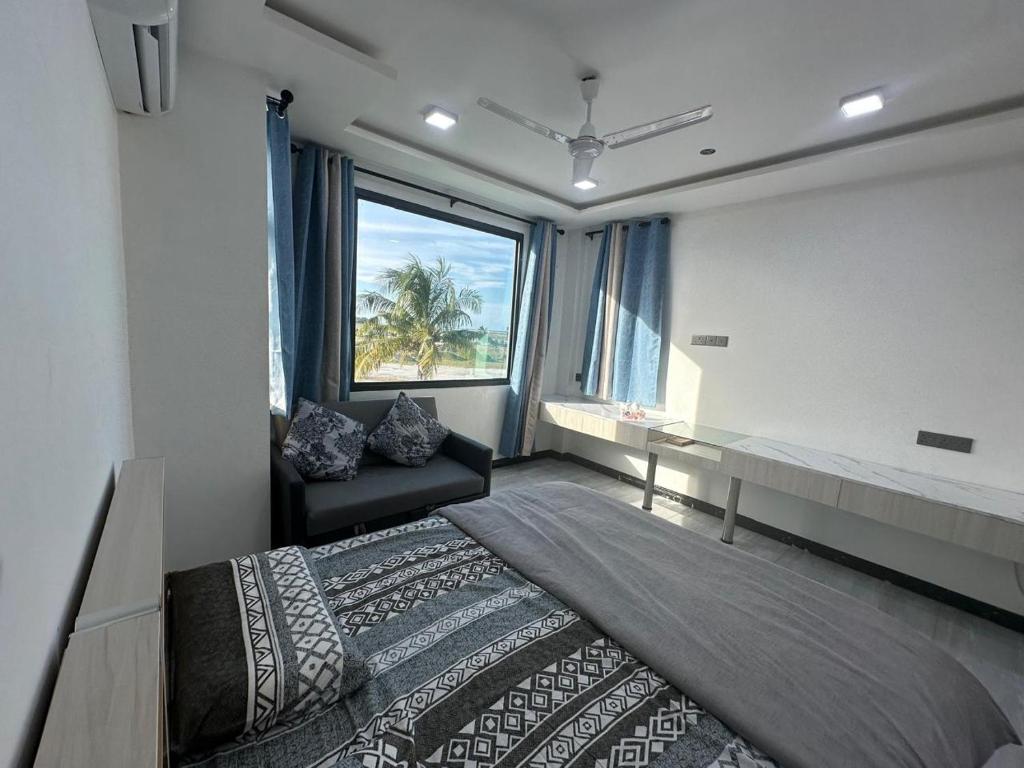 Guest room at Quest by Entrance with twin beds arranged together and a sofa by the window