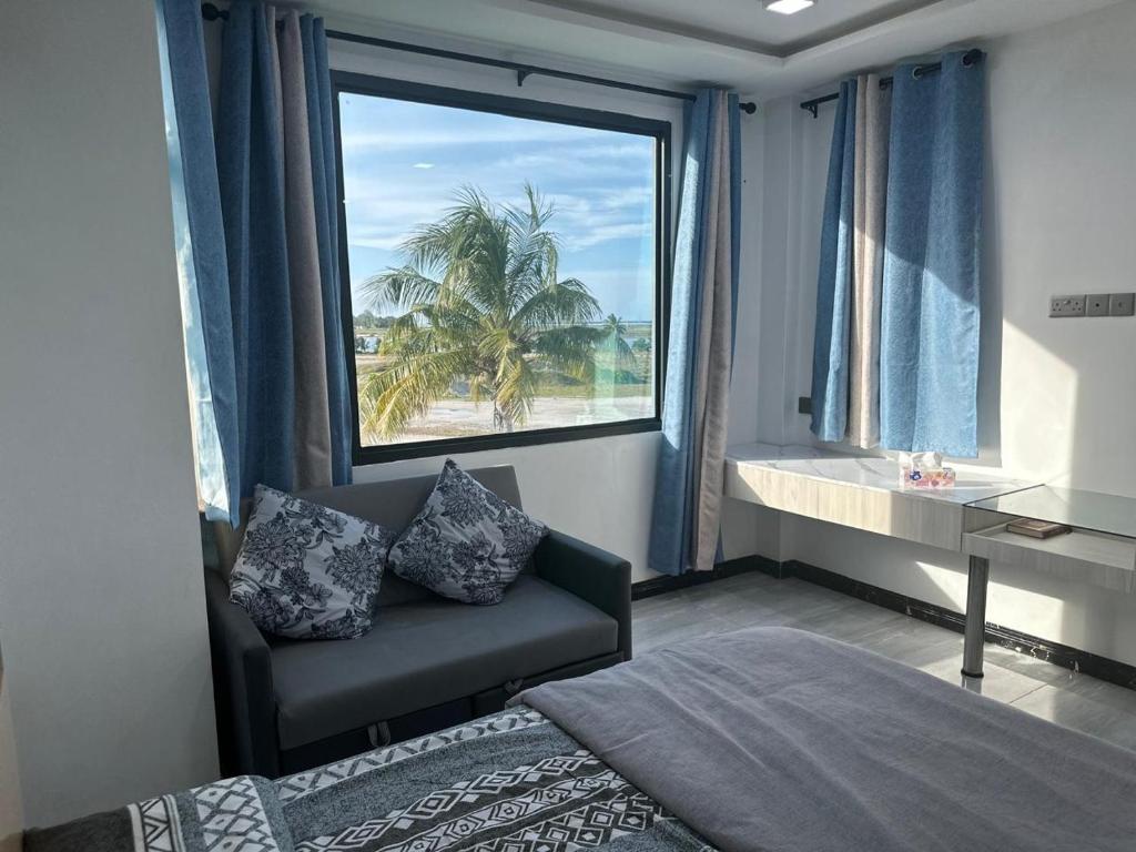 Bright ensuite room with connected twin beds, sofa and large window